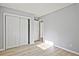 Bright bedroom with light gray walls, light wood flooring, and white closet doors at 1349 Heather Cir, Riverdale, GA 30296