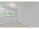 Bright bedroom featuring wood-look floors, a window with green outdoor view and crown molding at 1349 Heather Cir, Riverdale, GA 30296
