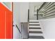 The entryway has black and white stairs, a modern railing and an orange front door at 1349 Heather Cir, Riverdale, GA 30296