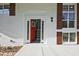 Close up of the red front door with side lights on a renovated single-story home with white painted brick at 1349 Heather Cir, Riverdale, GA 30296