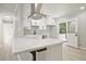 Modern kitchen with white cabinets, gray backsplash, island with gorgeous countertop, stainless hood, and access to deck at 1349 Heather Cir, Riverdale, GA 30296