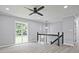 Living room with light gray walls, updated floors, ceiling fan and natural light from the large window at 1349 Heather Cir, Riverdale, GA 30296