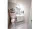 Bathroom with toilet, sink, mirror, shelf, light fixture, and gray tile flooring at 1431 Beckett Dr, Hampton, GA 30228
