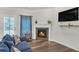 Cozy living room featuring a fireplace, dark wood floors, and a comfortable blue sofa at 1431 Beckett Dr, Hampton, GA 30228