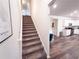 A staircase featuring a white handrail with gray carpet steps leads to the upper level of the home at 1431 Beckett Dr, Hampton, GA 30228