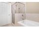 Bathroom with a glass-enclosed shower and a white bathtub at 255 Kendemere Pointe, Roswell, GA 30075