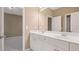 Double vanity with white cabinets, a large mirror, and tile flooring in a neutral palette at 255 Kendemere Pointe, Roswell, GA 30075
