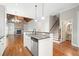 Modern kitchen with granite countertops, white cabinets, stainless appliances, and open view of the living area at 255 Kendemere Pointe, Roswell, GA 30075