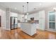 Open kitchen featuring stainless steel appliances, white cabinets, and a center island with a granite countertop at 255 Kendemere Pointe, Roswell, GA 30075