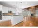 Open-concept kitchen and living area featuring white cabinetry, hardwood floors, and a stone fireplace at 255 Kendemere Pointe, Roswell, GA 30075