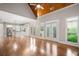 Open-concept living room with hardwood floors, vaulted ceilings, and view to a white kitchen with stainless appliances at 255 Kendemere Pointe, Roswell, GA 30075