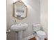 Powder room with pedestal sink, decorative mirror, and wood floors at 255 Kendemere Pointe, Roswell, GA 30075