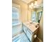 Well-lit bathroom vanity with white cabinets, sink, mirror, and a window with blinds at 3165 Blackshear Dr, Marietta, GA 30060