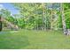 Large backyard with green grass, swing set, mature trees, and privacy fence at 435 Flowering Trl, Grayson, GA 30017