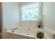 Bright bathroom featuring a large soaking tub next to a window with natural light at 435 Flowering Trl, Grayson, GA 30017