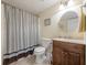 Cozy bathroom featuring a vanity with wood cabinets, a round mirror, and a shower-tub combo at 435 Flowering Trl, Grayson, GA 30017