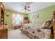 Bedroom with green walls, ceiling fan, carpet floors, and a bed with a floral comforter at 435 Flowering Trl, Grayson, GA 30017