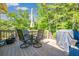 Outdoor deck with table, chairs, umbrella, and gas grill surrounded by lush trees at 435 Flowering Trl, Grayson, GA 30017