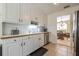 Bright kitchen with white cabinetry, stainless steel appliances and views into dining area at 435 Flowering Trl, Grayson, GA 30017