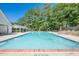 Large in-ground neighborhood pool with brick trim and white poolside gazebo and pool house in the background at 435 Flowering Trl, Grayson, GA 30017