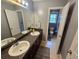 Bathroom featuring double sinks, granite counters, framed mirror, and neutral walls at 5578 Swanson Rd, Ellenwood, GA 30294