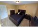 A well-lit bedroom featuring a dark bed set and warm yellow-colored walls at 5578 Swanson Rd, Ellenwood, GA 30294