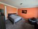 A cozy bedroom featuring a comfortable bed, sitting area, and warm orange-colored walls at 5578 Swanson Rd, Ellenwood, GA 30294