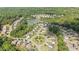 Aerial view showcasing a vibrant neighborhood with winding roads, lush greenery, and a scenic pond at 6310 Stillwood Ln, Cumming, GA 30041