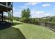 Spacious backyard with level lawn and view of lake is bordered by wooden fence for privacy at 6310 Stillwood Ln, Cumming, GA 30041