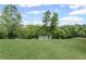 Expansive, gently sloping backyard with mature trees and a view of the lake creating a park-like ambiance at 6310 Stillwood Ln, Cumming, GA 30041