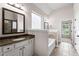 Bright bathroom featuring a garden tub, a granite vanity with stylish fixtures and neutral paint colors at 6310 Stillwood Ln, Cumming, GA 30041