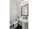 Elegant powder room features a pedestal sink, modern fixtures, and a decorative mirror for guests' convenience at 6310 Stillwood Ln, Cumming, GA 30041