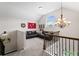 Bonus room with vaulted ceilings, a large window, comfortable sofas, a chandelier, and decorative elements at 6310 Stillwood Ln, Cumming, GA 30041