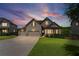 Two-story home with manicured lawn, beautiful landscaping, and a three-car garage at twilight at 6310 Stillwood Ln, Cumming, GA 30041