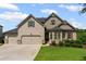 Charming two-story home with three-car garage, manicured lawn, and brick accents at 6310 Stillwood Ln, Cumming, GA 30041