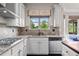 This kitchen features granite countertops, stainless steel appliances, stylish backsplash, and large window to backyard at 6310 Stillwood Ln, Cumming, GA 30041