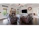 Inviting living room featuring a stone fireplace and leather furniture at 6310 Stillwood Ln, Cumming, GA 30041