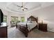 Serene primary bedroom features a tray ceiling, large windows, and luxurious furnishings for ultimate relaxation at 6310 Stillwood Ln, Cumming, GA 30041
