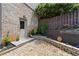 Private courtyard with brick-paved patio, privacy fence, planting bed and exterior door to basement at 6310 Stillwood Ln, Cumming, GA 30041