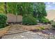 Landscaped backyard offers stone steps, retaining wall, and mature trees at 750 Highview Ct, Woodstock, GA 30189