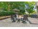 Relaxing backyard featuring a stone fire pit with an umbrella-shaded dining area at 750 Highview Ct, Woodstock, GA 30189