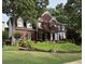 Charming two-story brick home featuring lush landscaping, a manicured lawn, and traditional architectural details at 750 Highview Ct, Woodstock, GA 30189