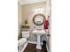 Stylish powder room features pedestal sink, decorative mirror, and modern fixtures with hardwood floors at 750 Highview Ct, Woodstock, GA 30189