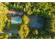 Aerial view featuring a community pool and tennis courts, surrounded by lush greenery at 1496 Shadowrock Dr, Marietta, GA 30062