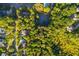 Aerial view showcasing a neighborhood tennis court surrounded by beautiful greenery and mature trees at 1496 Shadowrock Dr, Marietta, GA 30062