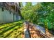 Landscaped backyard featuring tiered retaining walls, lush grass, and a charming banana tree at 1496 Shadowrock Dr, Marietta, GA 30062