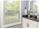 Bright bathroom features a black granite countertop, white cabinetry, and a window with white blinds at 1496 Shadowrock Dr, Marietta, GA 30062
