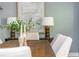 Close up of dining room table decor, side table and lamps, with view of upholstered chairs and hardwood floors at 1496 Shadowrock Dr, Marietta, GA 30062