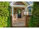 Inviting front porch with stone accents, dark wood door and hardware, and a natural wood porch and railing at 1496 Shadowrock Dr, Marietta, GA 30062