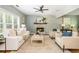 Bright living room with neutral furniture, hardwood floors, stone fireplace, ceiling fan, and large windows at 1496 Shadowrock Dr, Marietta, GA 30062